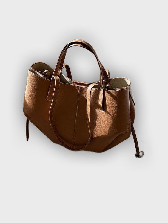 Bolso de mano diseñado con pliegues en los laterales