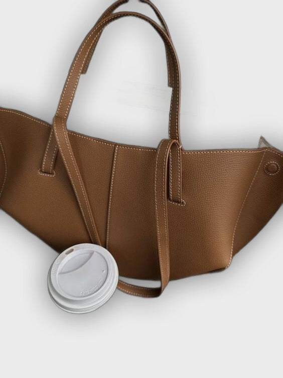 Bolso de mano diseñado con pliegues en los laterales