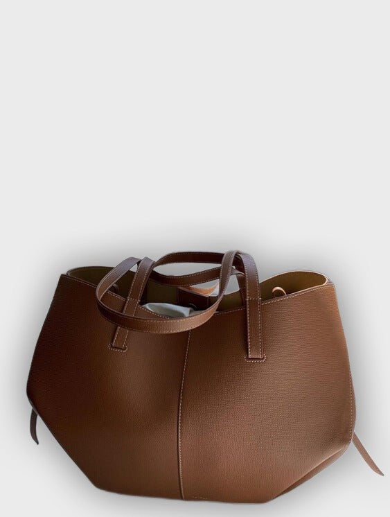 Bolso de mano diseñado con pliegues en los laterales